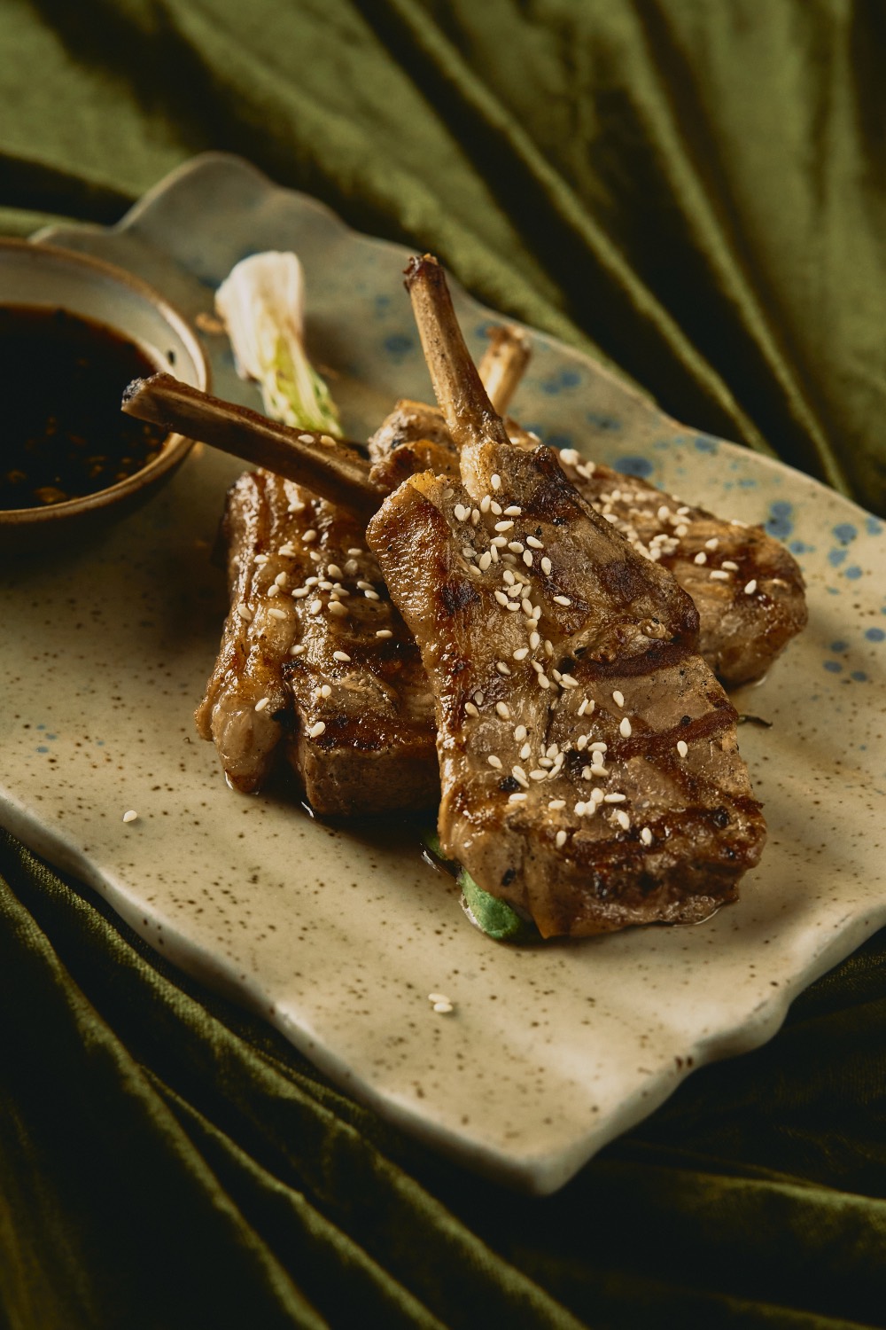 Char-grilled lamb chops finished with toasted sesame on hand-glazed ceramic